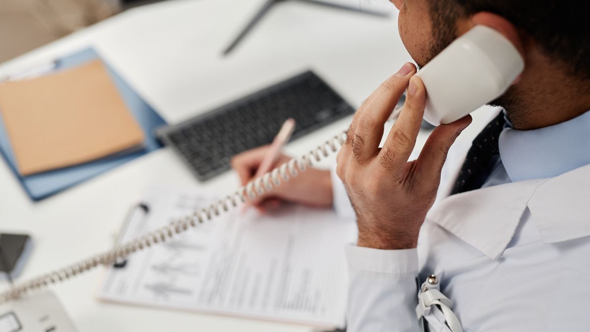 Staff member on phone documenting details to show fast follow up on physio clinic Meta ads leads