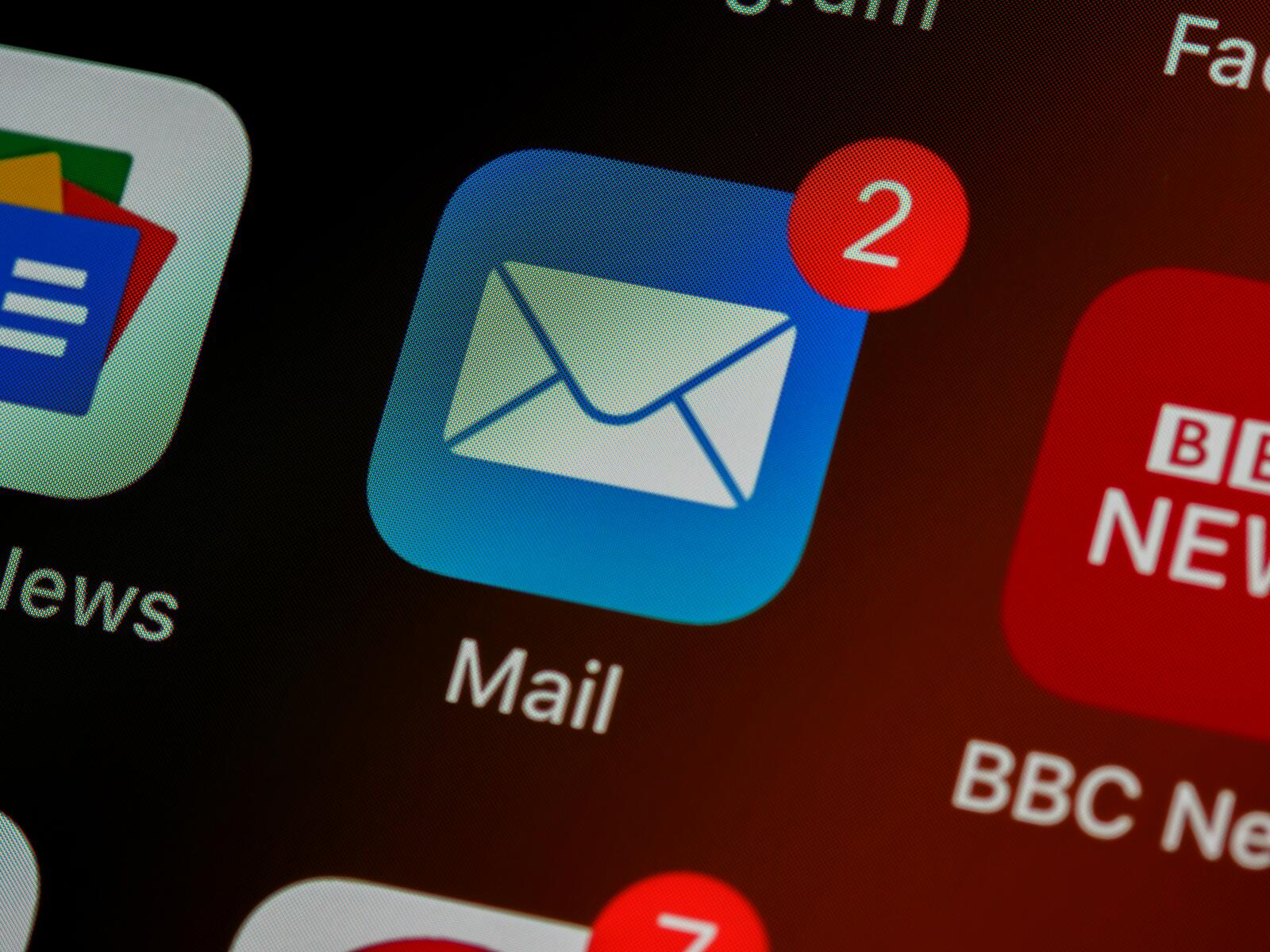 Close-up view of an email app icon with a notification badge showing two unread emails on a smartphone screen