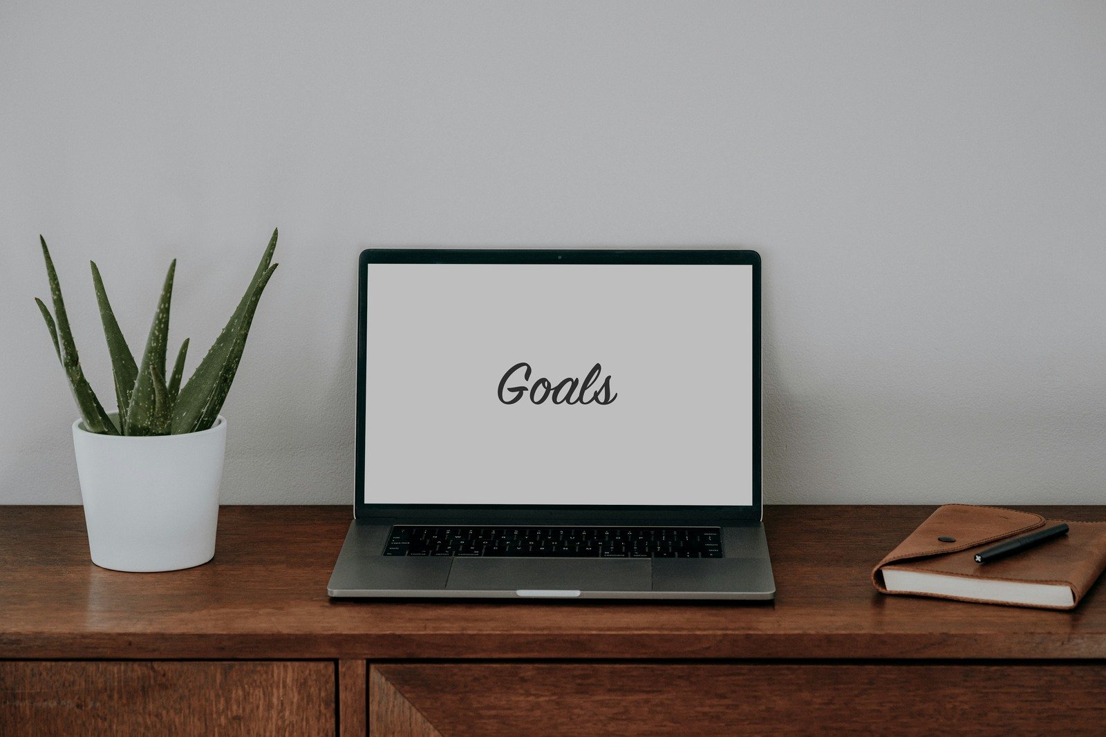 minimalist-workstation-with-goals-on-laptop-screen