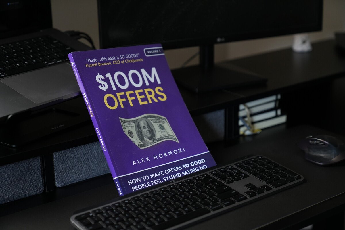 alex hormozis book 100 million offers sitting on desk marketing