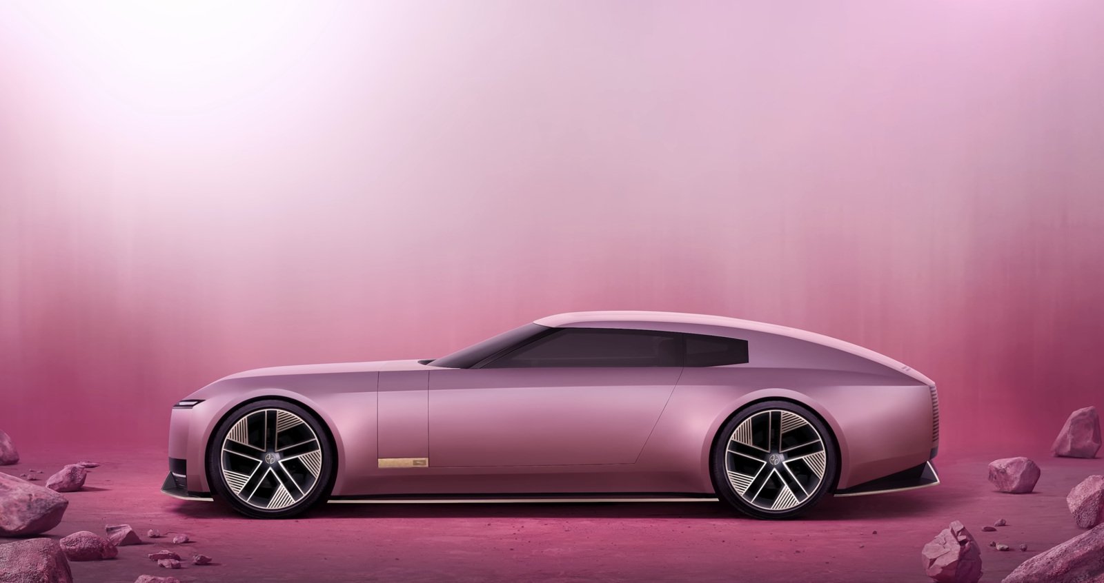 Jaguar's sleek, modern concept car in a metallic pink finish, displayed against a minimalist pink backdrop with scattered rocks. Highlights innovation and luxury.jpg