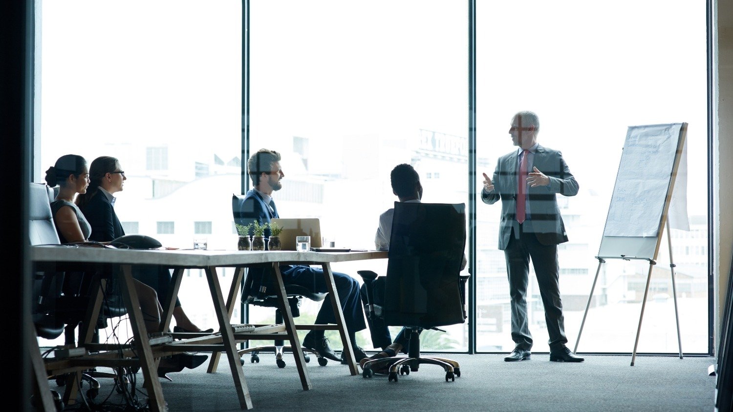 Business meeting where a consultant presents strategy options, representing how businesses evaluate marketing agencies