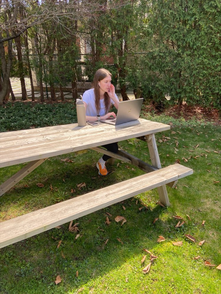 Tash working on a laptop at an outdoor picnic table